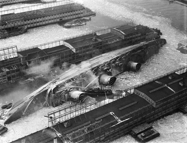 09 Feb 1942, New York, New York, USA --- Fireboats try to rescue workers trapped aboard the capsized and burning ship USS , formerly the , in New York Harbor. --- Image by © Bettmann/CORBIS