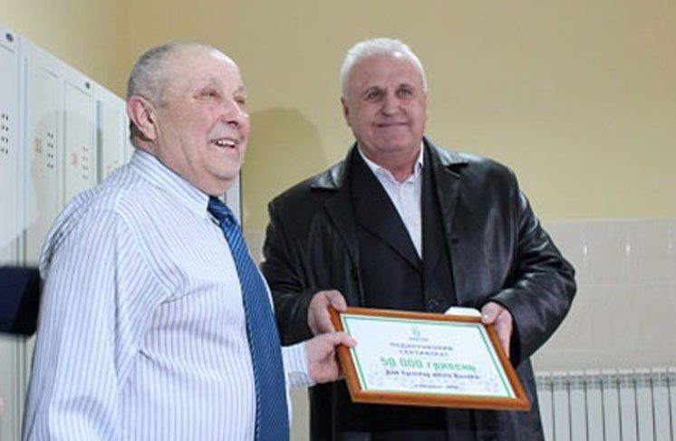 Представник «МРІЇ» Богдан Кушлик вручає подарунковий сертифікат директору школи Богдану Шелізі.